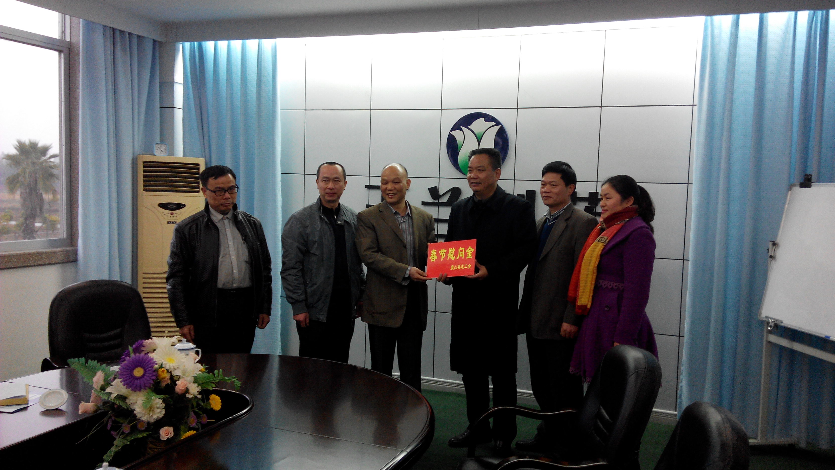 1月28日，梧州市總工會副主席謝海益帶隊到蒙山開展春節(jié)前慰問活動。圖為市總工會謝副主席給玉蘭制藥公司送上春節(jié)慰問金。--